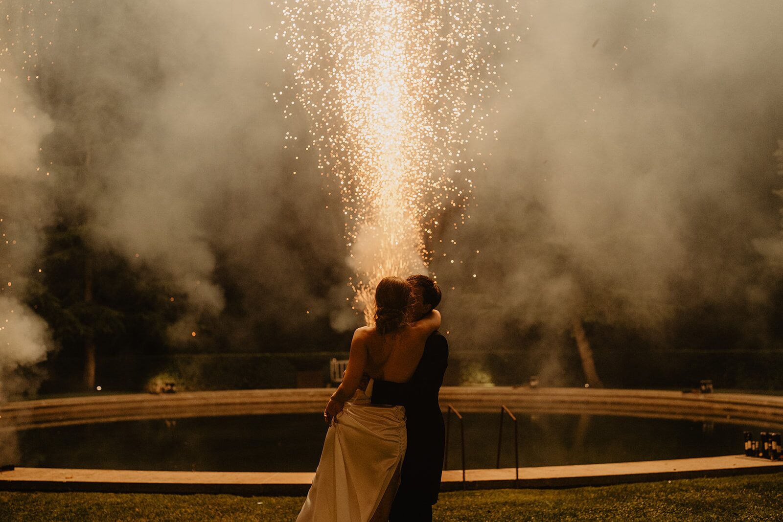 Novios abrazándose bajo fuegos artificiales en una boda de lujo en Barcelona diseñada por The Eve